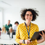 Portrait of teacher with seniors attending computer and technology education class.